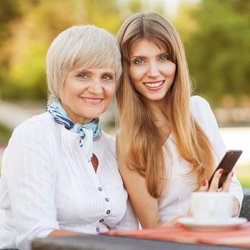 Adult Mother And Daughter Drinking Tea Or Coffee And Talking