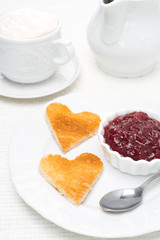 toasted bread in the shape of heart with berry jam