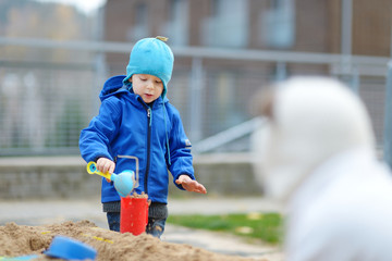 Two kids playing in a sandbox