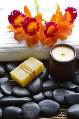 Candle ,soap , Orchid on towel and pebbles