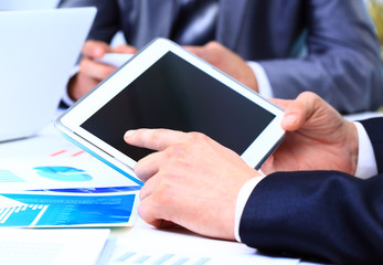 Close-up of touchpad in businessman hands during meeting