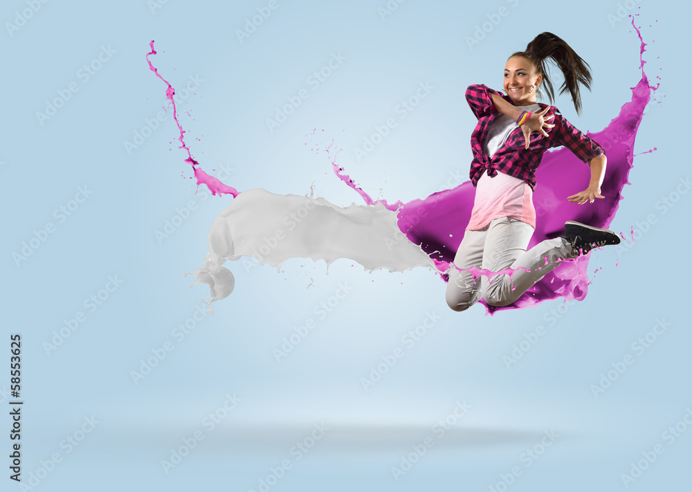 Wall mural young female dancer jumping with splash of paint