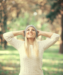 Happy woman looking up in the sky in Autumn forest