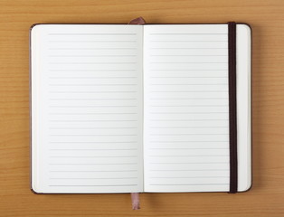 Empty lined paper notebook on a wood background