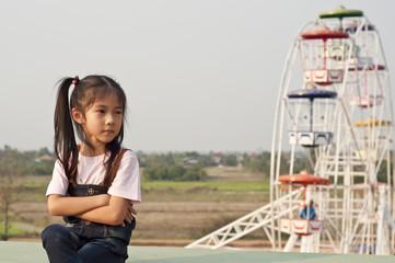 Little Asian girl in amusement park.