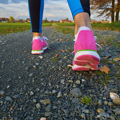 Sporty female walking and running on a road
