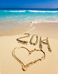 2014 inscription on the sand near the sea.