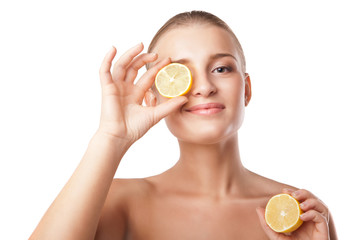 woman holding lemon slice in front of eye