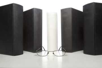 five standig hardcover books with a reading glasses in front