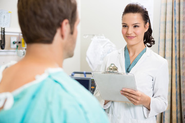 Doctor With Clipboard Smiling At Patient