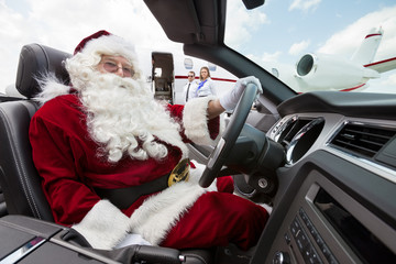 Santa Driving Convertible At Airport Terminal