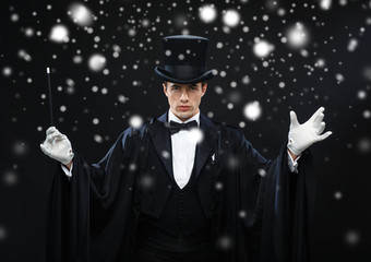 magician in top hat with magic wand showing trick