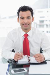 Fototapeta premium Smiling businessman writing in diary at office