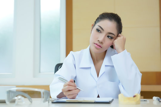 Bored woman dentist looking very boring at her desk