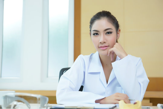 Attractive young female doctor sitting at desk in office