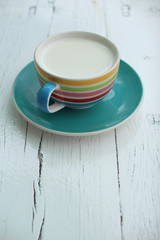 Hot goat milk cup on white grunge board
