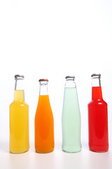 Four assorted soda bottles on white