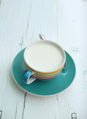 Hot goat milk cup on white grunge board