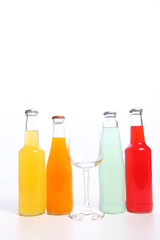 Four assorted soda bottles on white