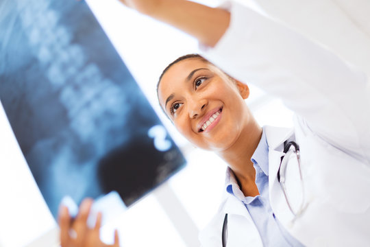smiling female doctor studying x-ray