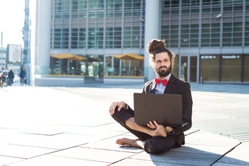 Stylish elegant dreadlocks businessman using notebook - obrazy, fototapety, plakaty