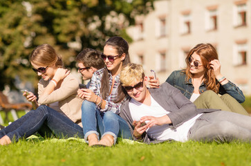 Fototapeta premium students looking at smartphones and tablet pc