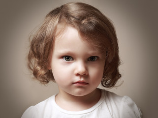 Angry little kid girl portrait looking. Closeup