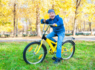 boy rides a bicycle in park