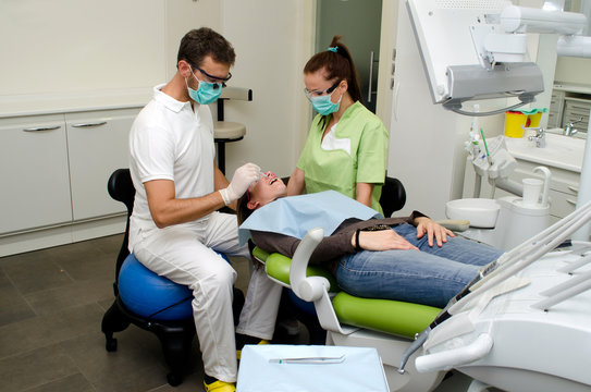 Dentist, assistant and patient in dental clinic