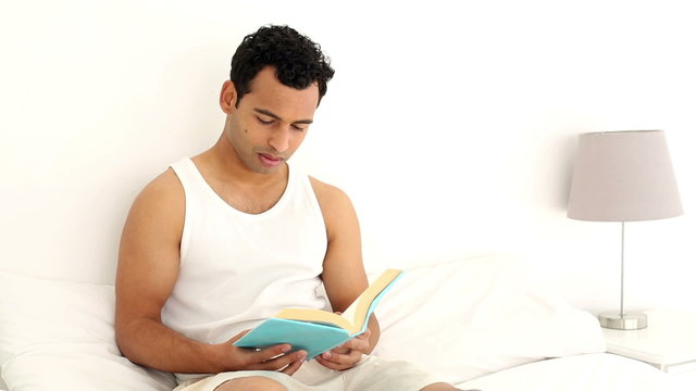 Happy handsome man reading a book