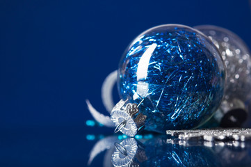 Blue and silver xmas ornaments on dark blue background