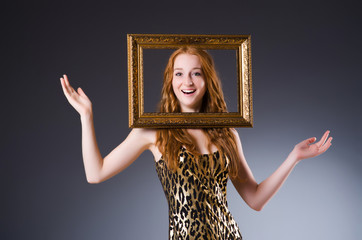 Redhead with picture frame against dark background