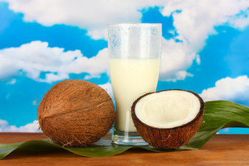 glass of coconut milk and coconuts on sky background close-up