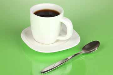 A cup of strong coffee on green background