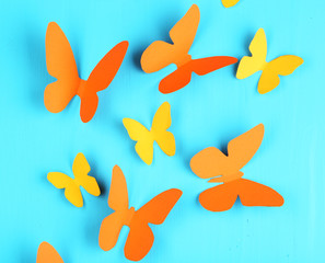 Paper butterflies on blue wooden board background