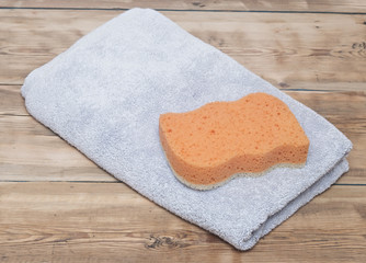 Sponge and towel on wood background