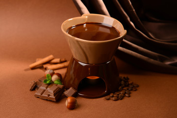 Chocolate fondue, on brown background