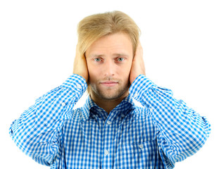 Young man closes his ears isolated on white