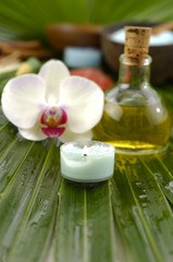 Obraz na płótnie Canvas orchid with,candle, oil ,salt in bowl on palm leaf texture