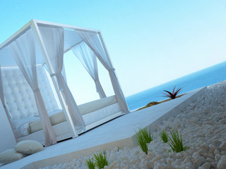 White four-poster bed standing outdoors with seascape view
