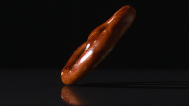 Pretzel spinning on black surface