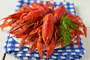 A plate of boiled crayfish on a blue checkered napkin