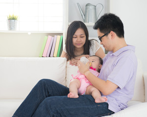 chinese asian parents feeding baby boy at home