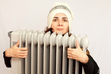 Young woman holding an electric  heater