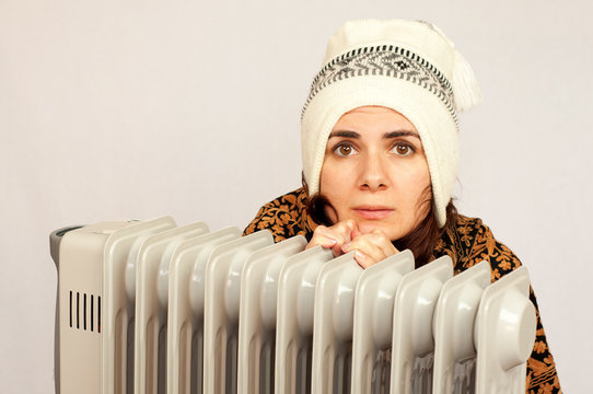 Young Woman Freezing Near The Heater