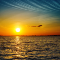 summer orange sunset over darken sea