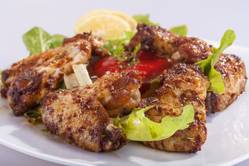 fried chicken wings in sauce with lemon and tomato sauce