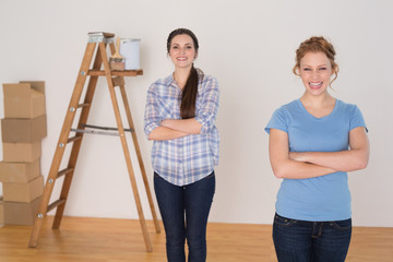 Friends standing with arms crossed in a new house