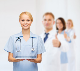 Fototapeta premium smiling female doctor or nurse with tablet pc