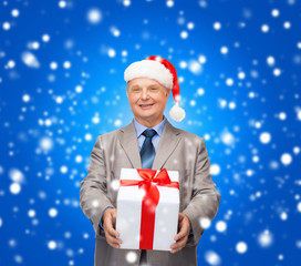 smiling man in suit and santa helper hat with gift
